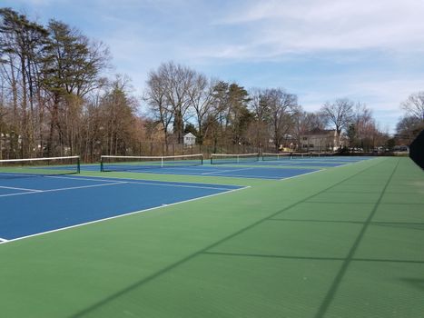 green and blue surface tennis courts with nets