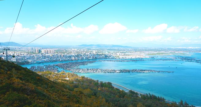 Cable car with tourists inside and against the background of the Hainan Province, China