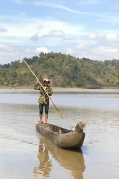 Dak Lak, VIETNAM - JANUARY 6, 2015 - Man pushing a boat with a long pole