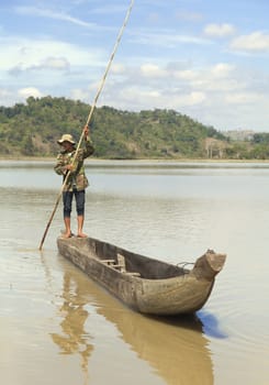 Dak Lak, VIETNAM - JANUARY 6, 2015 - Man pushing a boat with a long pole