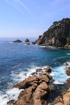 Top view on the rock in the deep blue sea on a sunny summer day