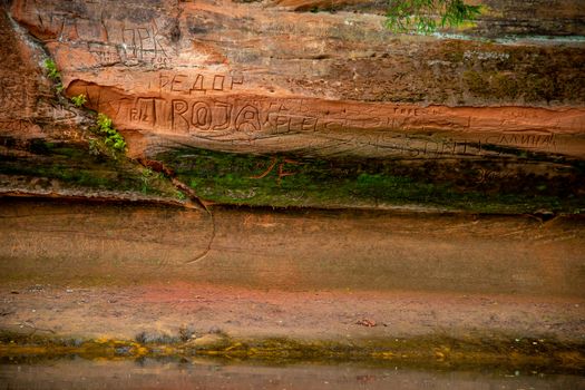 Closeup of sandstone cliff formation near the river Gauja in Latvia. Sedimentary rock consisting of sand or quartz grains cemented together.