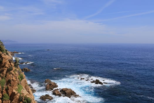 Top view on the rock in the deep blue sea on a sunny summer day