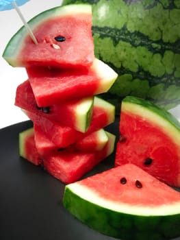 Freshly Chopped Red Summer Watermelon on a Black Dish