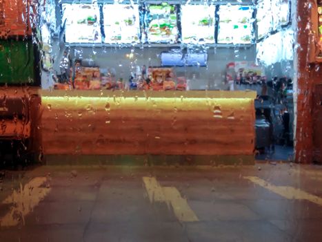 Fast Food Counter on a Rainy Day through Wet Window Glass