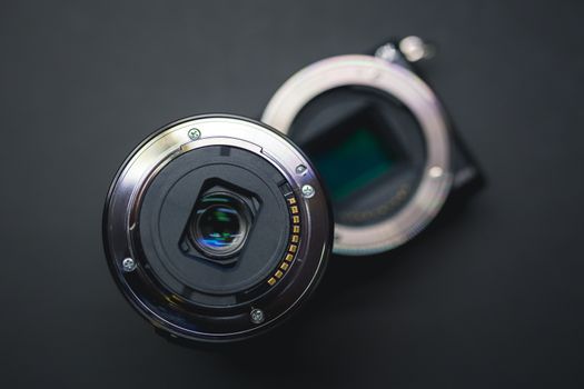 Close-up of mirrorless digital APS-C camera with deattached lens. Shot form above.