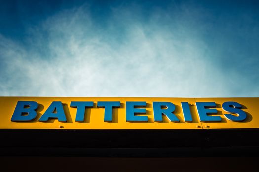 Bright Garish Sign For Batteries At A Garage