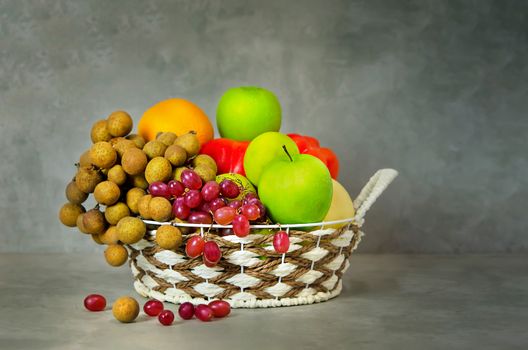 fresh vegetables and fruits in wicker basket over wooden background