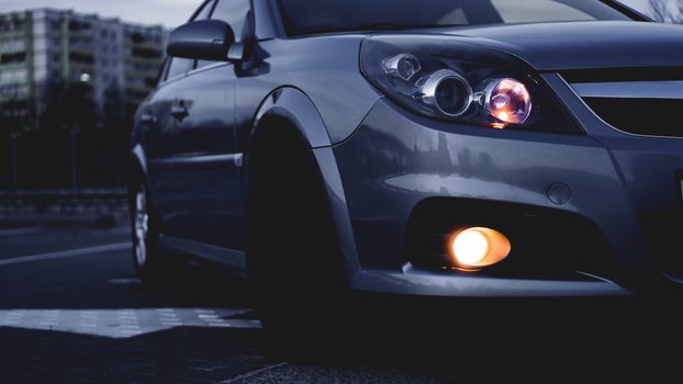 Close up of modern sedan headlamp. Front view shot from side of vehicle. Car headlight background.