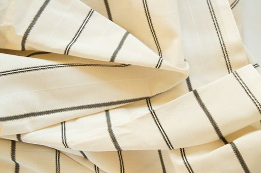 Beige linen fabric with black stripes, the texture of the fabric, the weaving industry or material for sewing