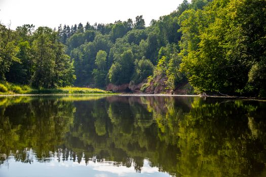 Landscape with cliff near the river Gauja and forest in the background. The Gauja is the longest river in Latvia, which is located only in the territory of Latvia. 

