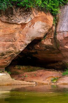 Closeup of sandstone cliff formation with cave on bank of river Gauja in Latvia. The Gauja is the longest river in Latvia, which is located only in the territory of Latvia. 