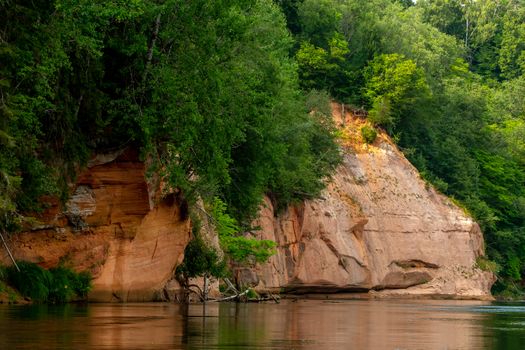 Landscape of cliff with cave near the river Gauja and forest. Gauja is the longest river in Latvia, which is located only in the territory of Latvia. 