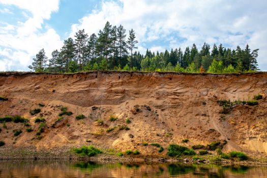 Landscape with cliff near the river Gauja, blue sky and trees. Gauja is the longest river in Latvia, which is located only in the territory of Latvia. 