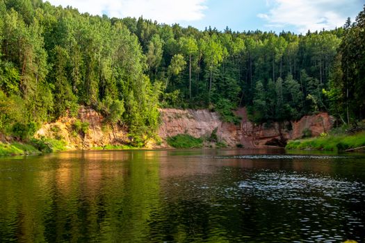 Landscape with cliff, flowing river and green forest in Latvia. Gauja is the longest river in Latvia, which is located only in the territory of Latvia. 