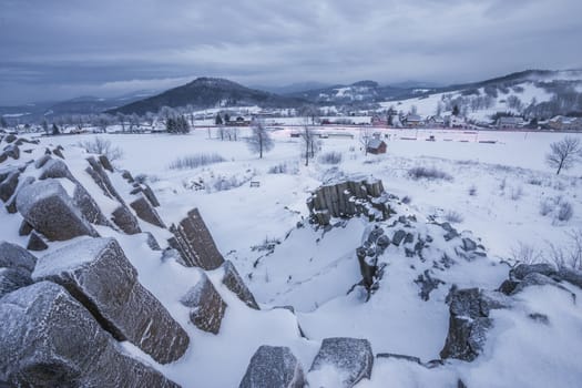 Winter basalt formation Panska skala, close Kamenicky Senov in Czech Republic. Exposed basalt poles of burned out volcano.