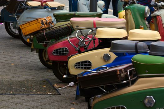 Various retro scooters line the road in a row.