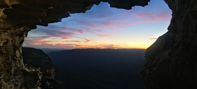 Scenic panorama views to sunset from mountain cliff cave
