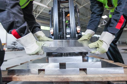 Workers taking aluminium billet at CNC machine shop