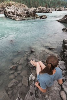 Woman resting at river in Altai Mountains territory