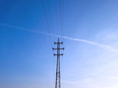 High-voltage lines and cables onthe blue sky background.
