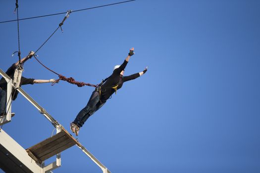 Elderly woman jumping from a bridgeJumping from the bridge with a rope. RoupeJumping