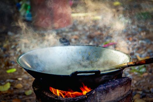 Iron pan for cooking On the fireplace with smoke