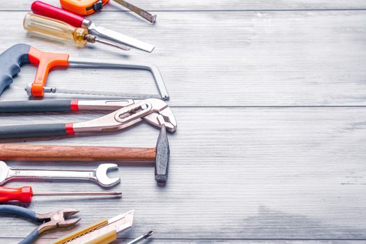 Screwdriver,hammer,tape measure and other tool for construction tools on gray wooden background with copy space,industry engineer tool concept.still-life.