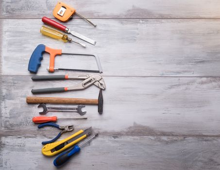 Screwdriver,hammer,tape measure and other tool for construction tools on gray wooden background with copy space,industry engineer tool concept.still-life.