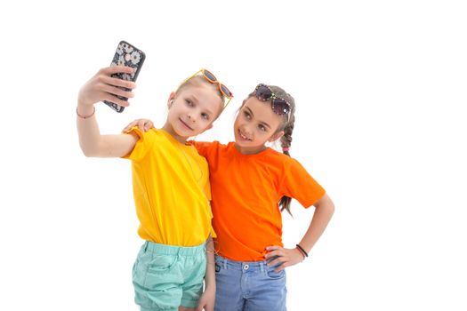 Two teen girls taking selfie with mobile phone on white background