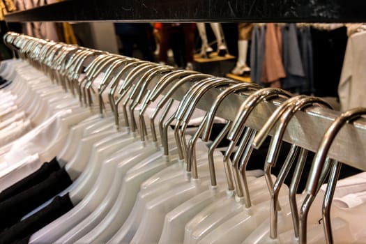 Hangers with clothes in a row in the store. Things on hangers