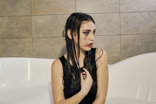 Young woman portrait with dripping smeared makeup dressed in the black bathing suit posing in the bathroom. Conceptual fashion photography for design. Young woman for lifestyle design.