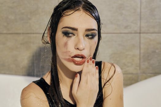 Young woman portrait with dripping smeared makeup dressed in the black bathing suit posing in the bathroom. Conceptual fashion photography for design. Young woman for lifestyle design.