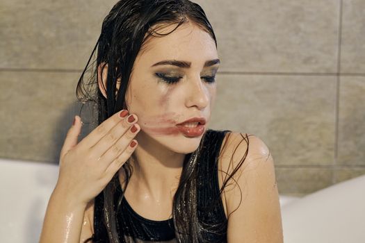 Young woman portrait with dripping smeared makeup dressed in the black bathing suit posing in the bathroom. Conceptual fashion photography for design. Young woman for lifestyle design.