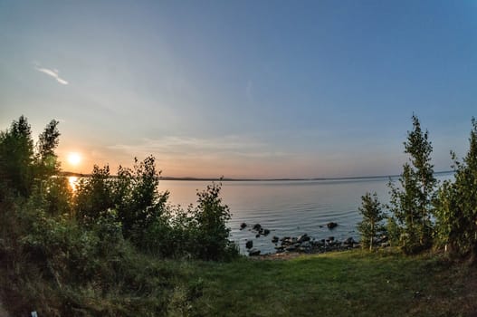 the evening sky over the lake, solar path glows on the water