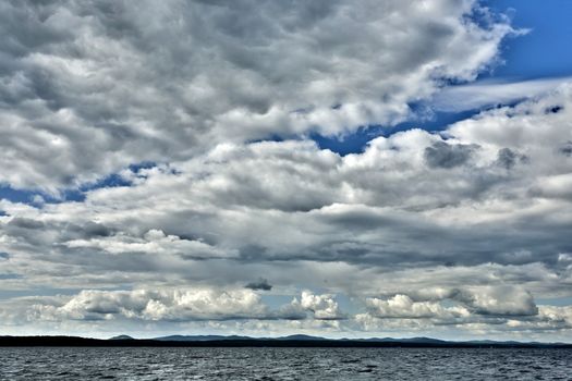 day lake in gray-white cloudy weather, South Ural, Uvildy, in the distance are seen the Ural mountains