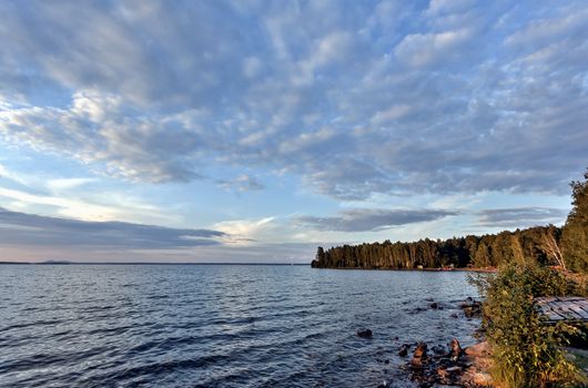 evening lake in cloudy weather, South Ural, Uvildy, in the distance are seen the Ural mountains
