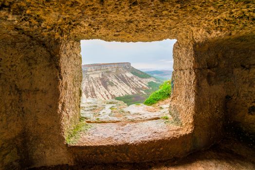 View of the mountain in the window of the cave city of Chufut-Kale, Crimea, Russia