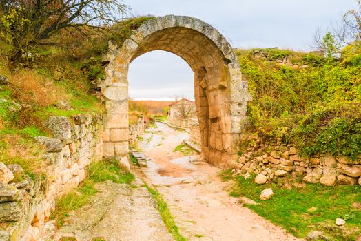 Ancient stone road and ruins of an arch in the cave town of Chufut-Kale, Crimea, Russia