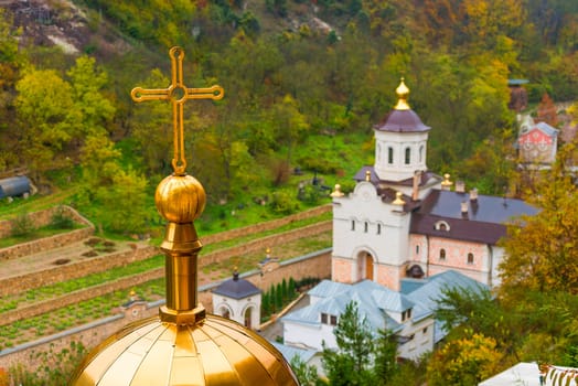 Golden dome of the Orthodox Russian church with a cross, close-up