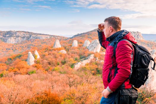 Hiking in the mountains, a traveler admiring the autumn mountains