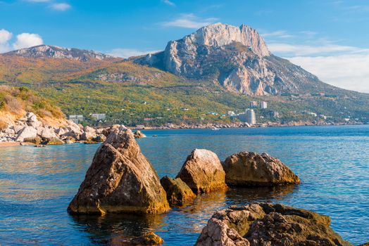 Sticking stones from sea water with a beautiful view of the mountains, picturesque seascape