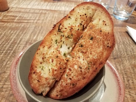 slices of seasoned garlic bread in a bowl on a table