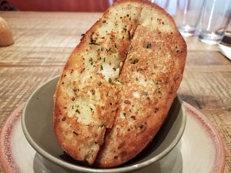 slices of seasoned garlic bread in a bowl on a table