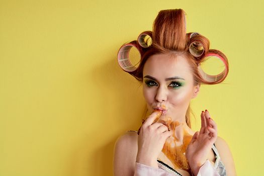 Young redhead woman with shugaring paste on her hands, face, body and chest. Young redhead woman with hair curlers. Advertising concept of shugaring paste. Skin care concept with copyspace.