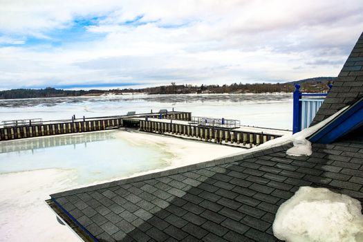 A dock and lake iced over in the winter