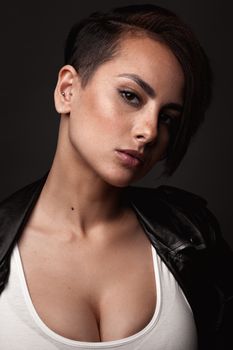 Beauty sexy woman in a leather jacket. Portrait on a dark background