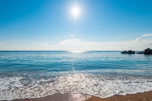 The seascape is a bright midday sun over clear sea water, a view of the horizon.