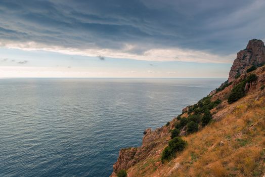 Dramatic sky, rocky coast and calm sea before the storm