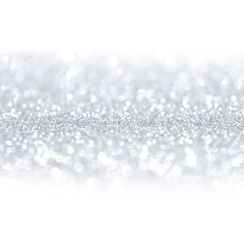 Silver festive glitter background with defocused lights